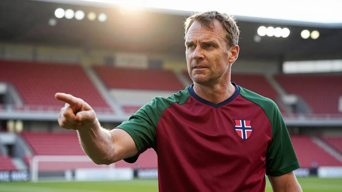 A 35-year-old Norwegian scout, dressed in a plain dark red and green polyester training top, stands on the KFUM Arena...